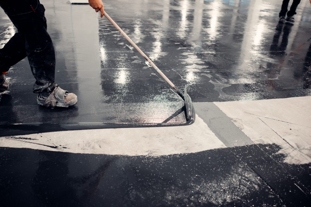 Worker applies gray epoxy reisin to a new floor. Modern Surface Posadzka Antyelektrostatyczna 1024x683